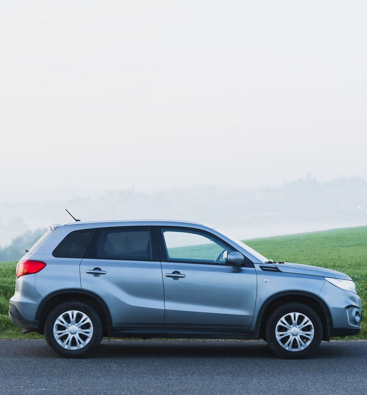 A silver SUV parked on a foggy countryside road in Zbraslavice, Czech Republic.